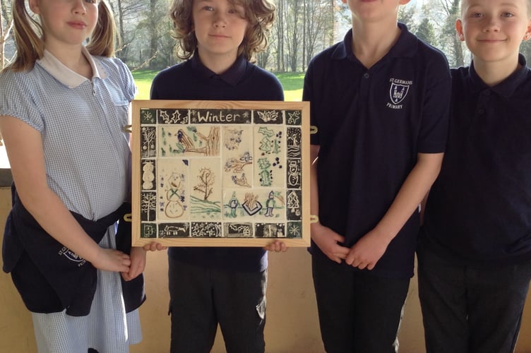 Some of the St Germans Primary School pupils with a framed montage of the pottery tiles they have made