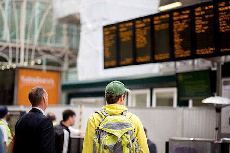 Passengers checking a departures board at a large railway station