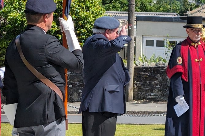 A veteran gives a salute after laying a wreath
