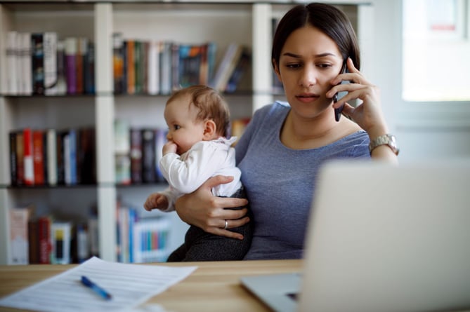 Worried mother using mobile phone an laptop at home