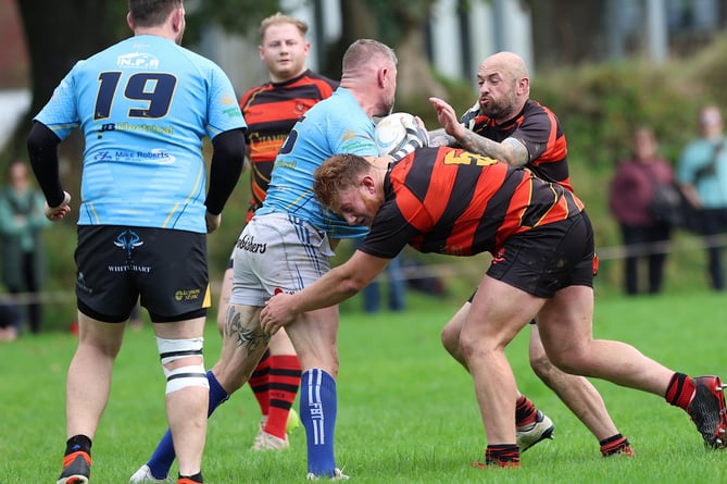 Liskeard-Looe lock Oscar Sanders-Mortimer goes in for a tackle with fly-half Mike McCarthy in support. Picture: Glen Rogers