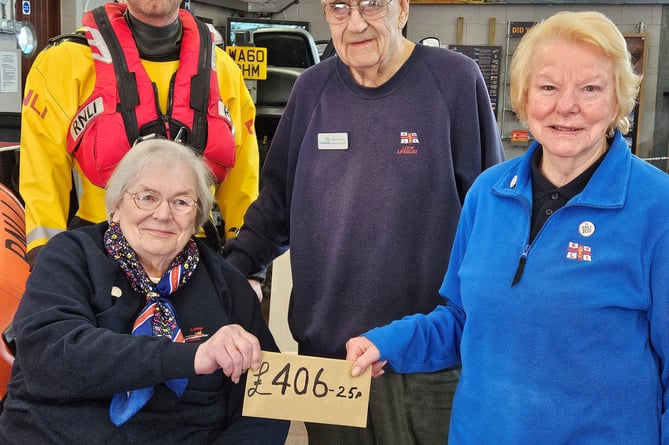 Marilyn Berry accepting a donation from Barbara and David Jones with their grandson Goron Jones, a volunteer crew with the lifeboat. (Photo credit: RNLI Andrew Jones)