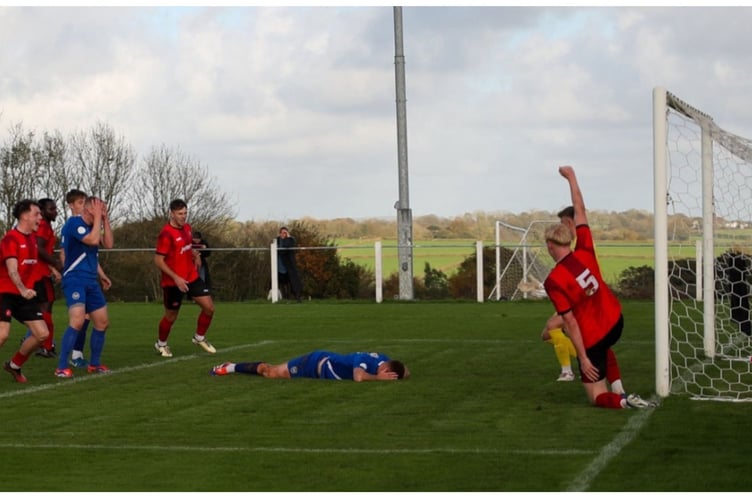 Delight and despair in equal measure as Dobwalls' players celebrate after Charlie Castlehouse's free-kick was helped into the net by Newquay midfielder Cam Turner. Picture: Colin Hilton