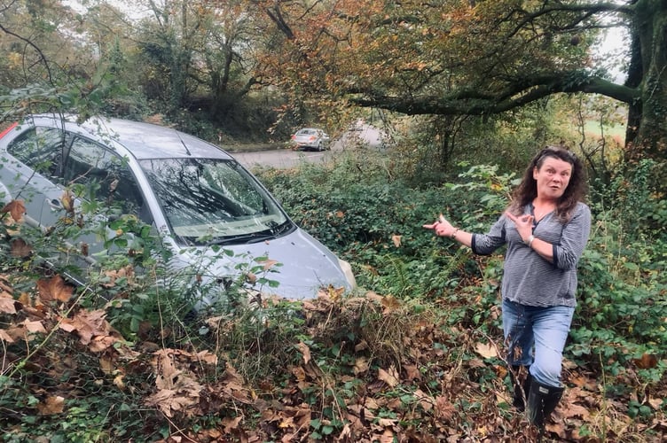 Resident Lyn Jones with the vehicle which ended up at the end of her garden on the B3252 at Horningtops. (Picture: Lyn Jones)