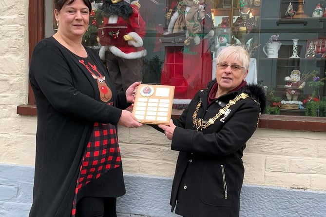 Town Mayor Christina Whitty presents Sarah Stewart, owner of Trinkets and Treasures, with the trophy for Best Dressed Christmas Window in Liskeard. 