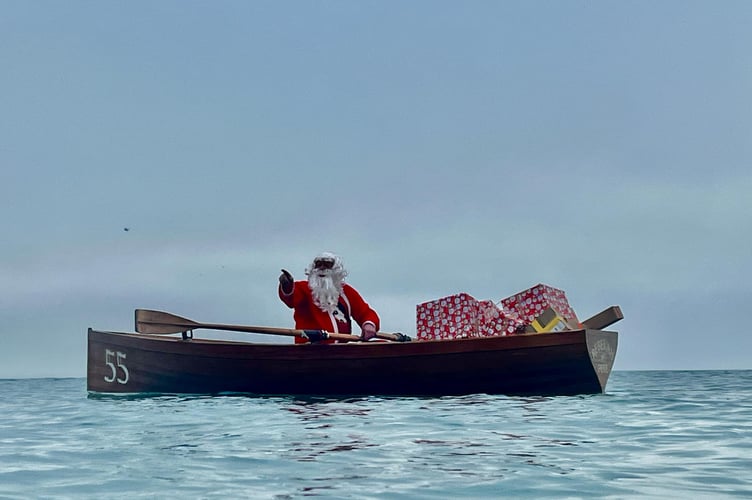 Santa swapped his reindeer and sleigh for a more seaworthy form of transport as he accompanied the swimmers at Looe on Christmas Eve. (Picture: Guy Cooper)